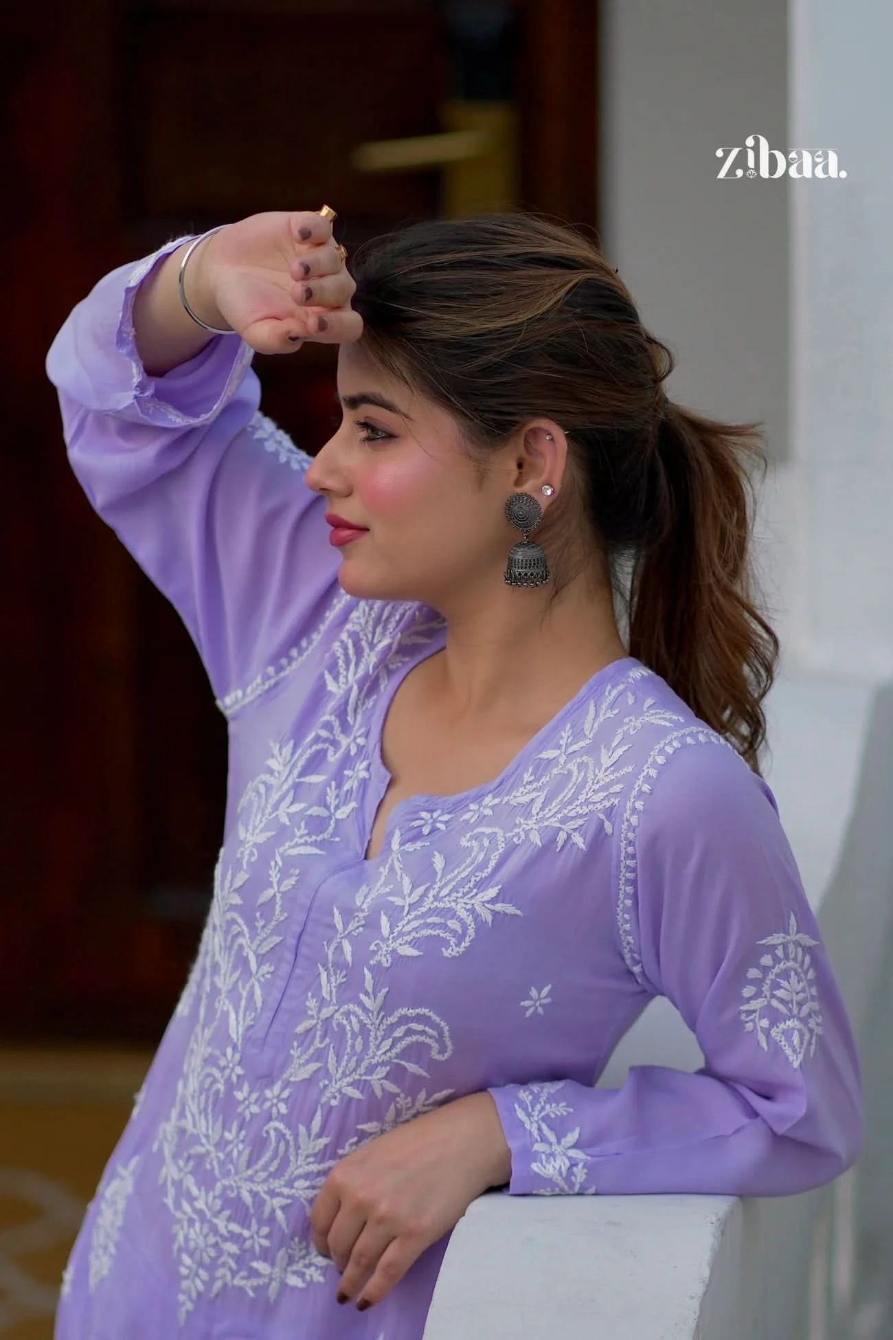 Model dressed in a lavender chikankari kurti featuring intricate embroidery, shot outside.