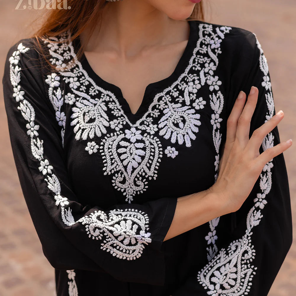 Black dress with white embroidery on a blurred background