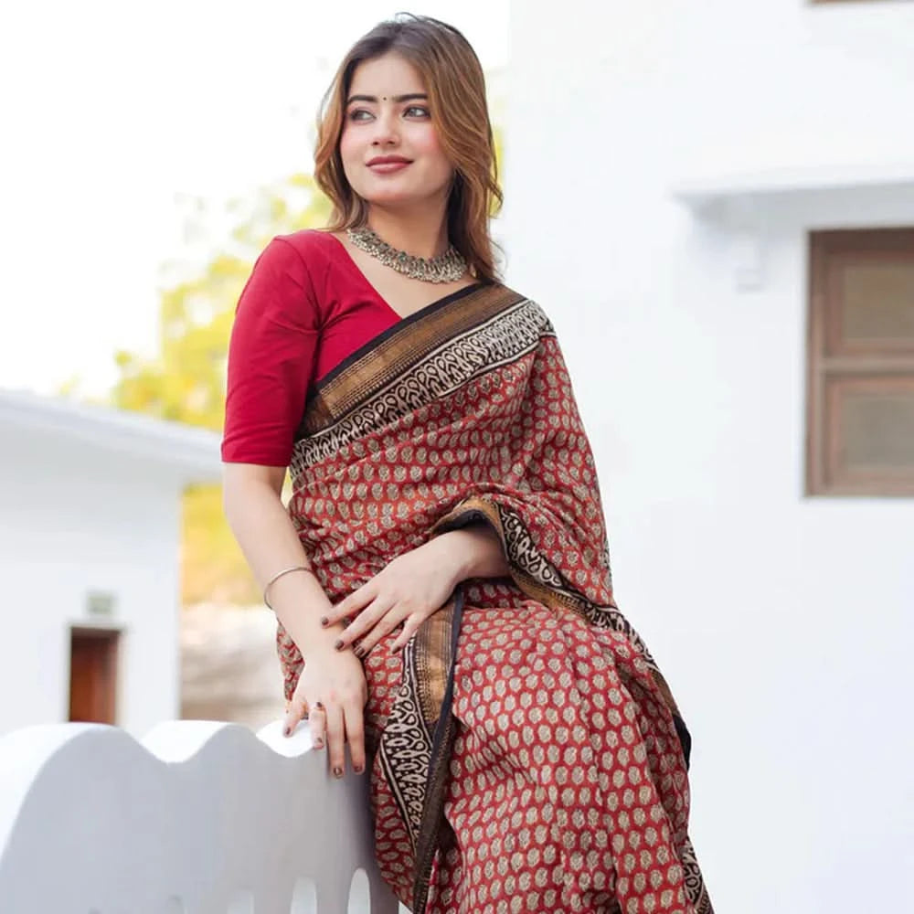 Woman wearing a red and brown saree with a white background