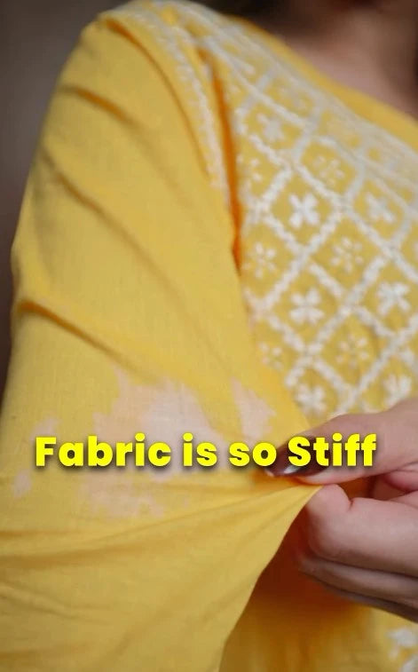 Yellow fabric with a textured pattern, held by hands, with text 'Fabric is so Stiff'.