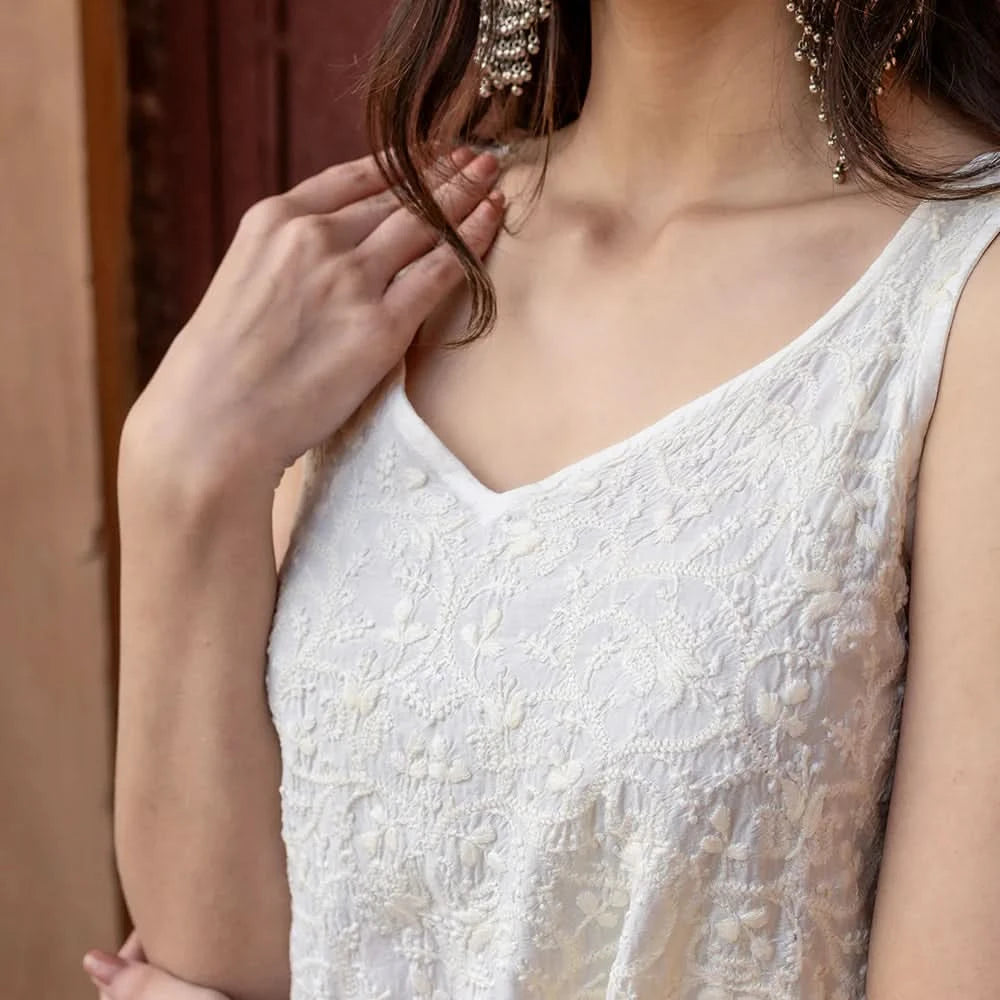 Close-up of a person wearing a white lace dress with a blurred background