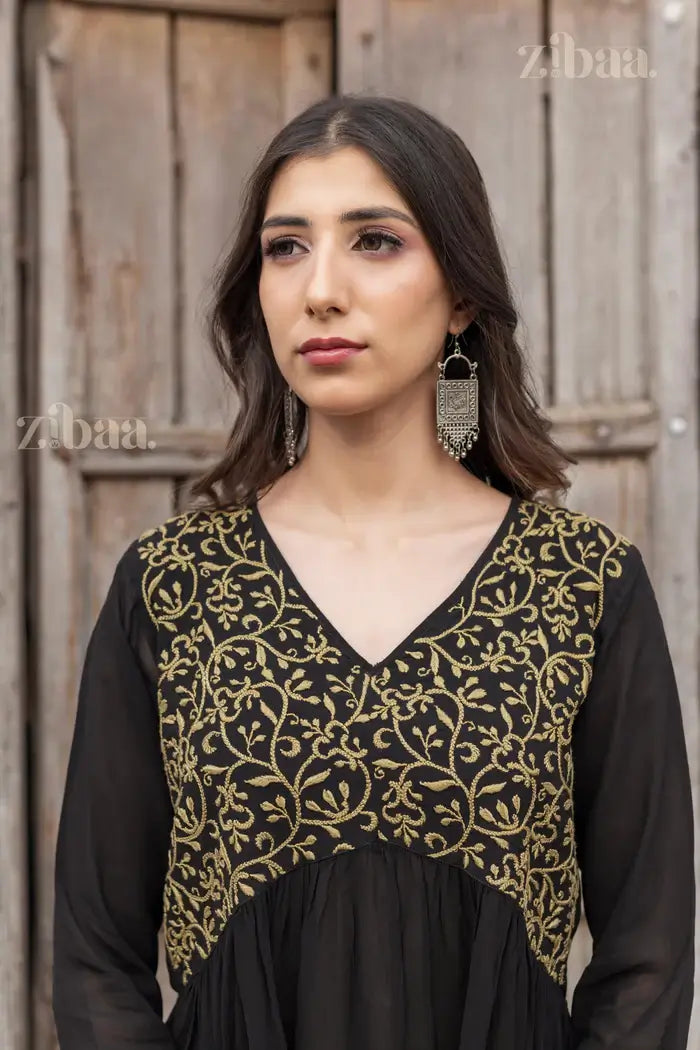 Close-up of a model in a Black Chikankari Kurti with intricate gold embroidery, paired with statement earrings for a graceful look.