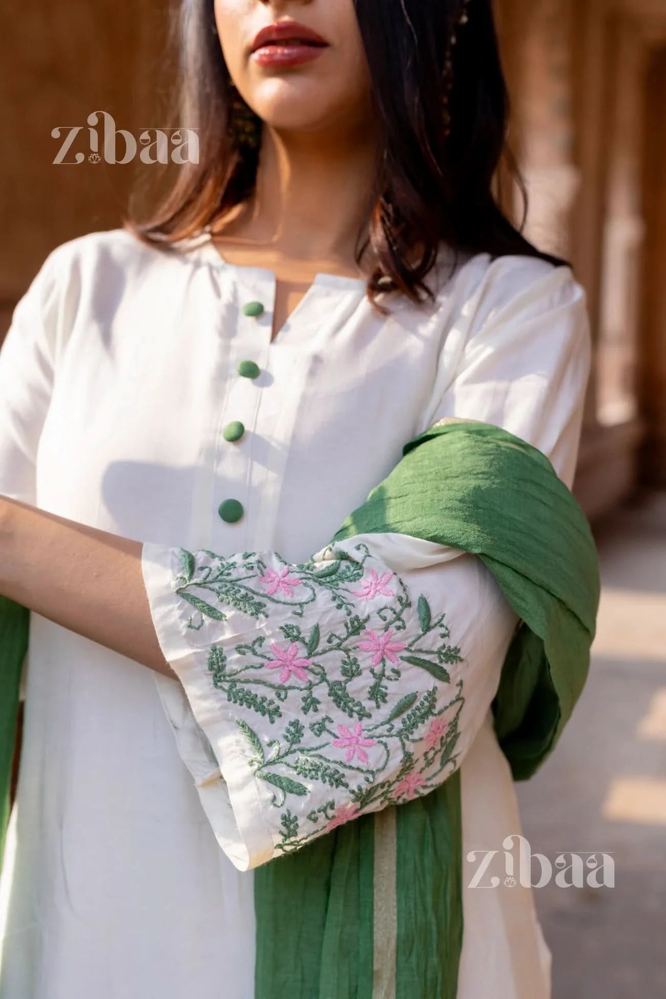 Woman dressed in a Pure Muslin White Chikankari Kurta Set with floral embroidery and a sage green dupatta.