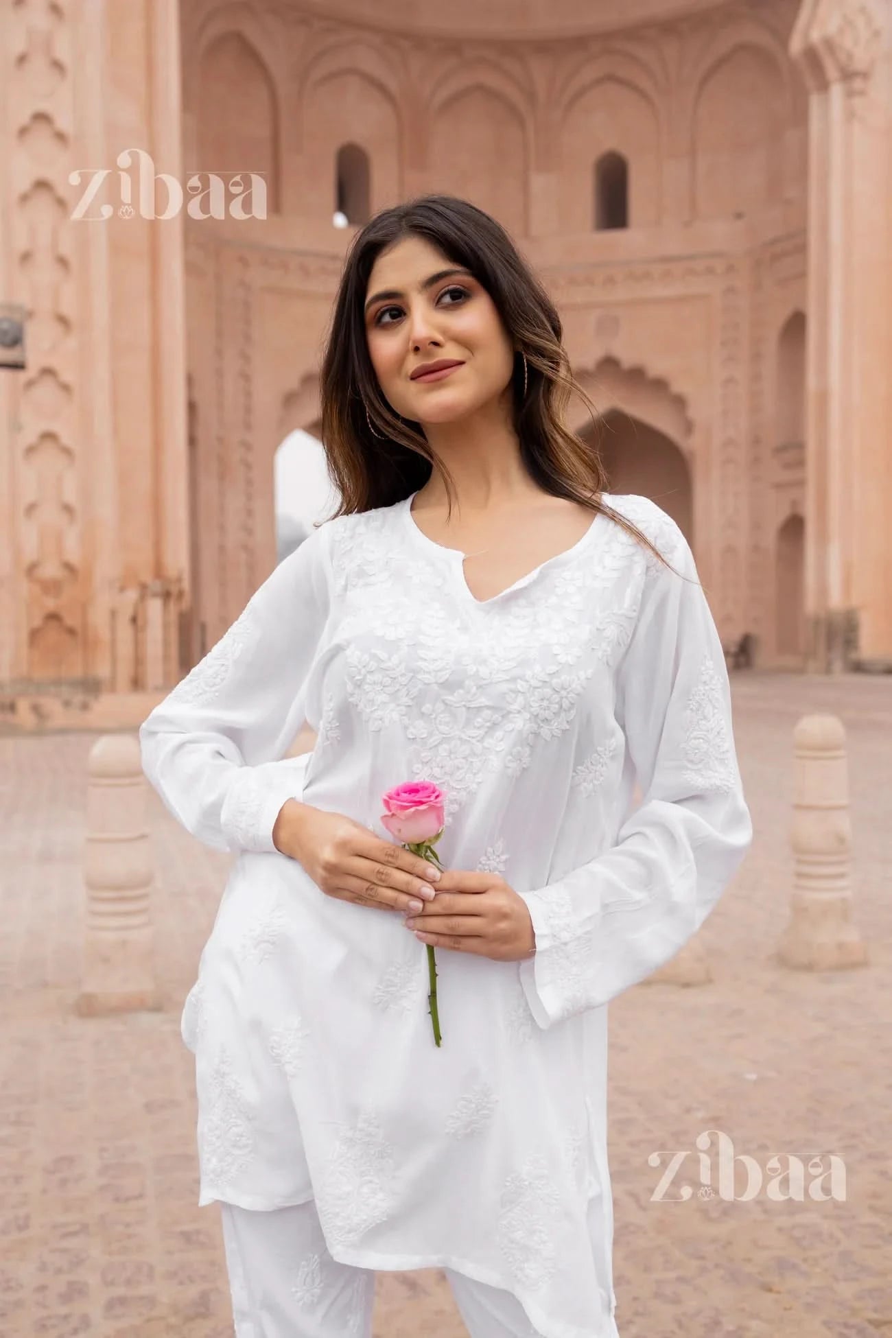 Casual outdoor shot of woman in white short chikankari kurti.