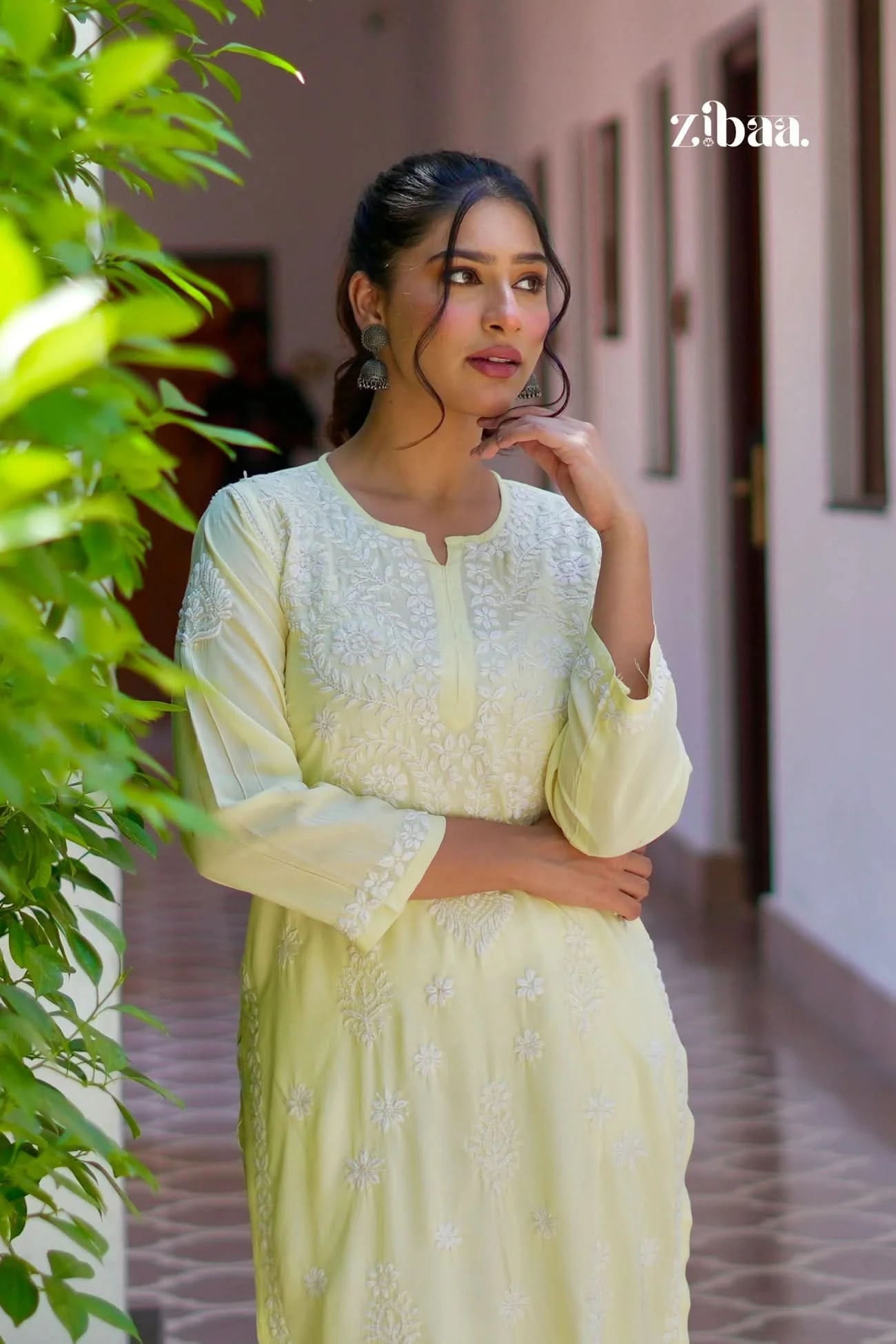 Model wearing a yellow chikankari kurti outdoors, highlighting detailed chikankari work.