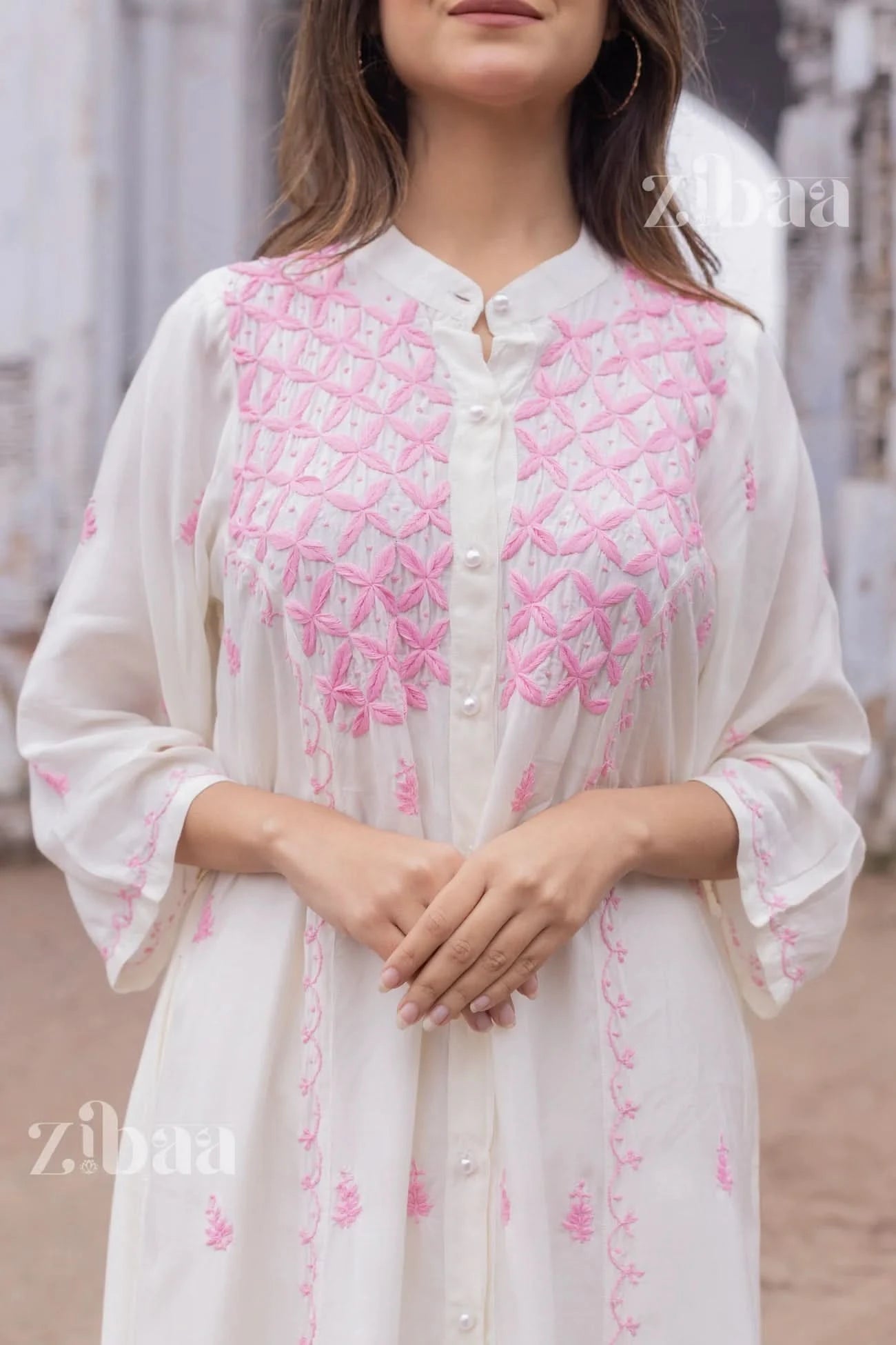 Model wearing a white chikankari kurta outdoors, showcasing fine hand stitching on the fabric.