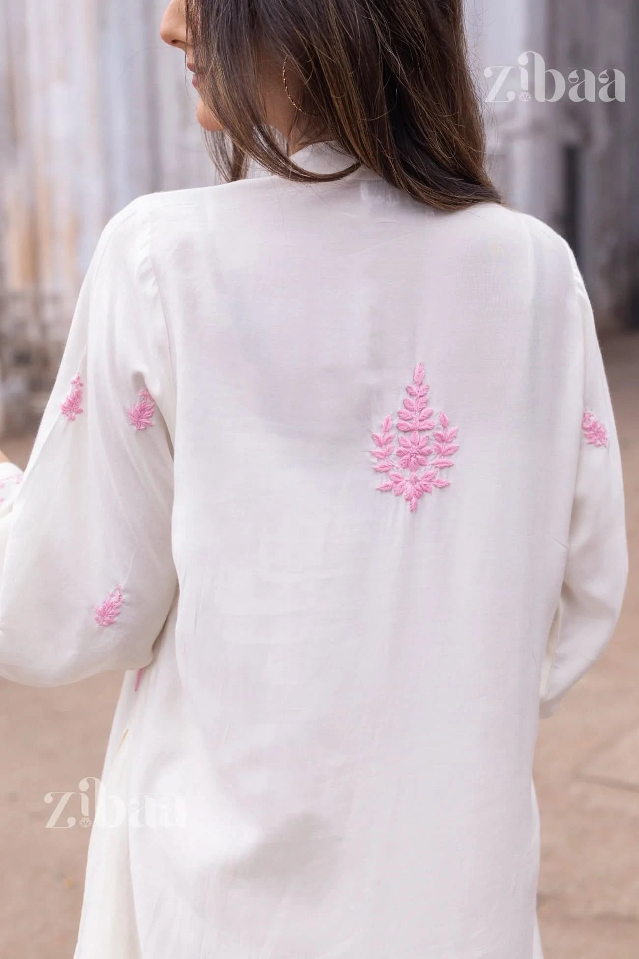 Backshot of a woman in a white chikankari kurta photographed outdoors with visible intricate stitching.
