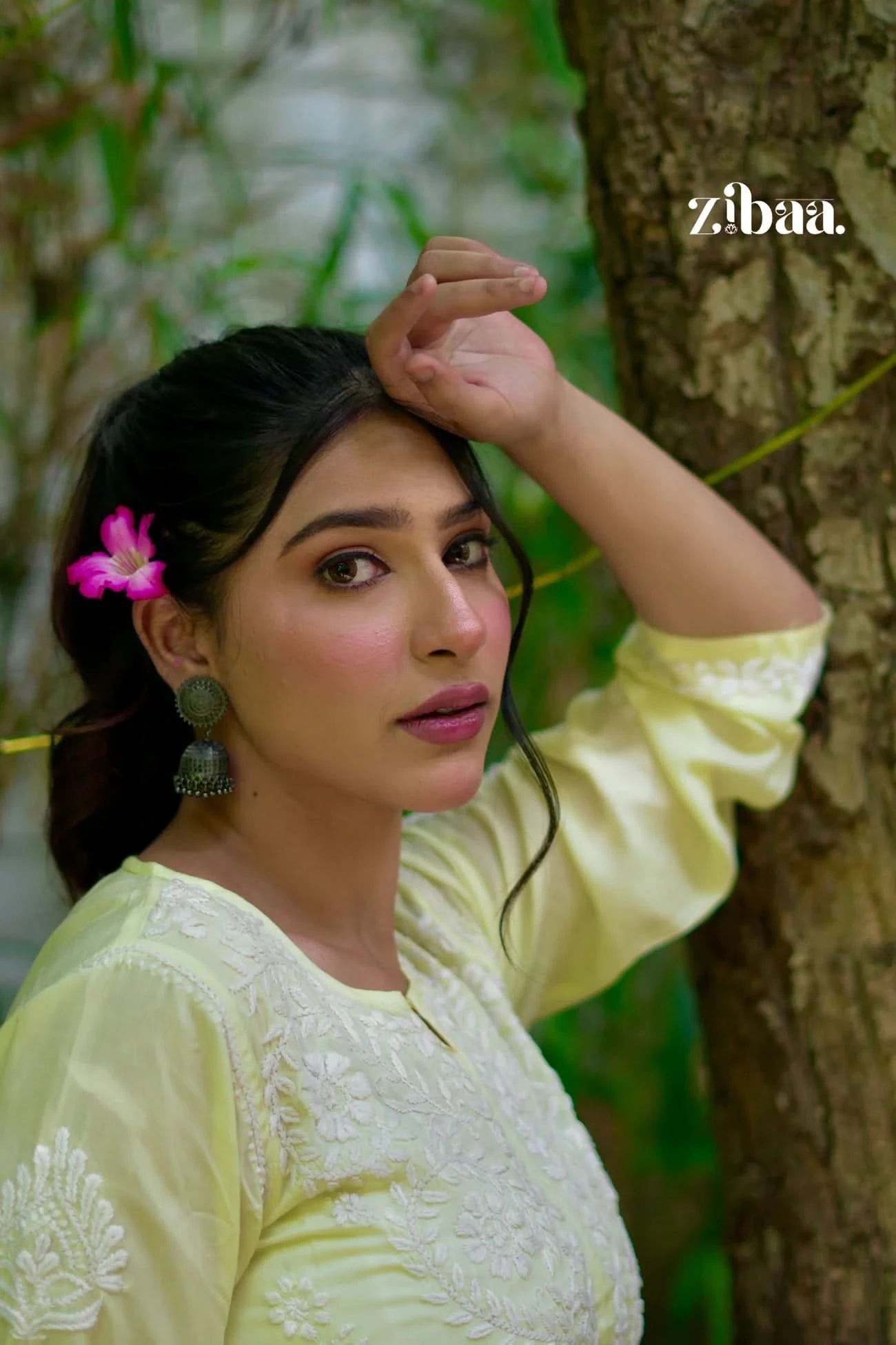 Yellow chikankari kurti with visible threadwork, styled on a model in an outdoor setting.