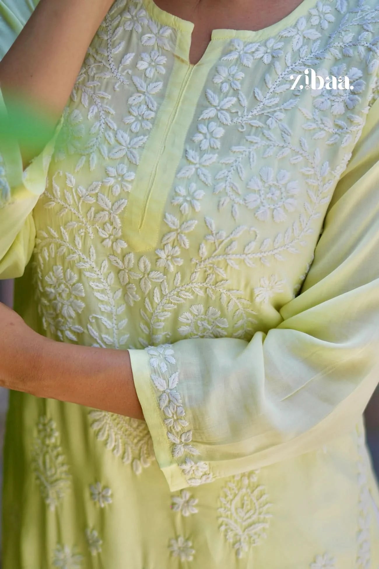 Yellow chikankari kurta with visible fine hand embroidery, captured in a close-up on a model for detailed fabric showcase.