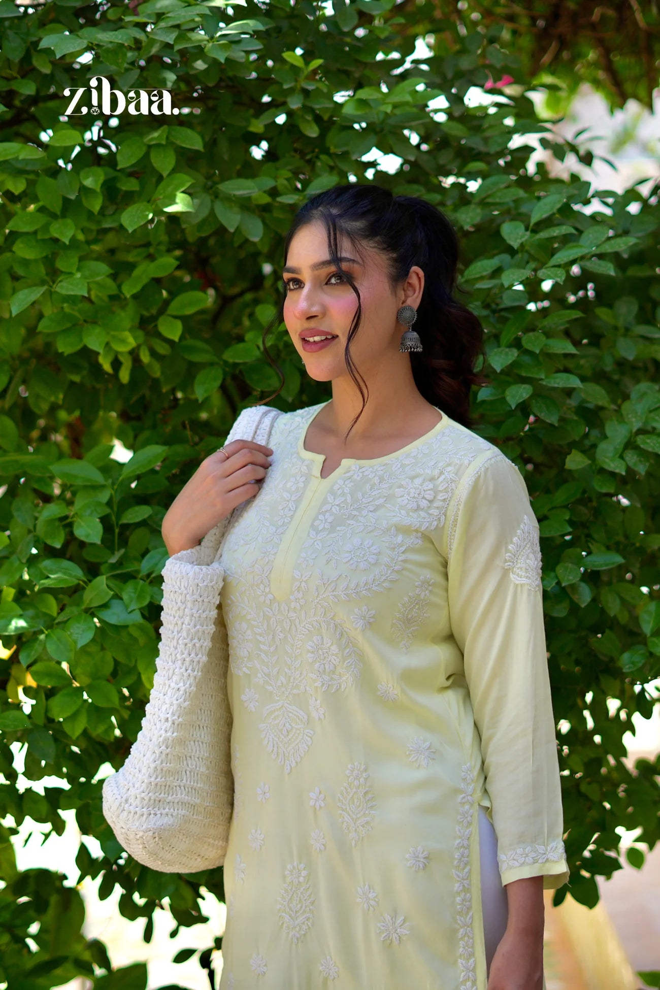Yellow chikankari kurti with visible chikankari detailing, worn by a model in subtle outdoor light.